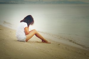 Lonely girl crying on the beach