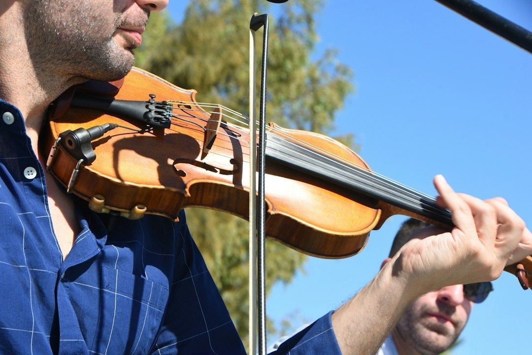 Nærbilde av musiker som spiller hardingfele utendørs